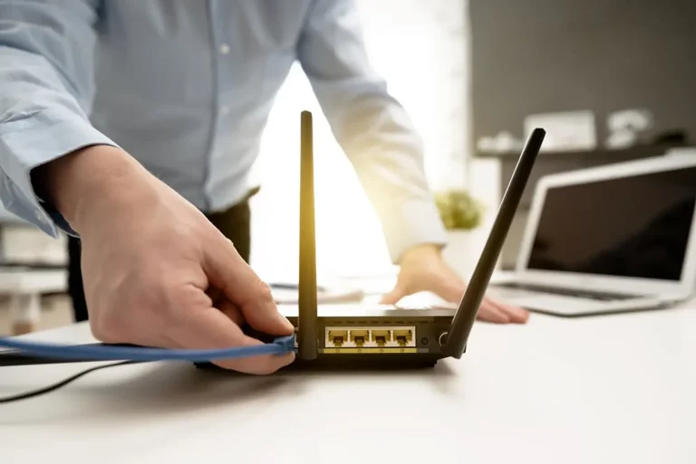 Man plugging cable into wireless router
